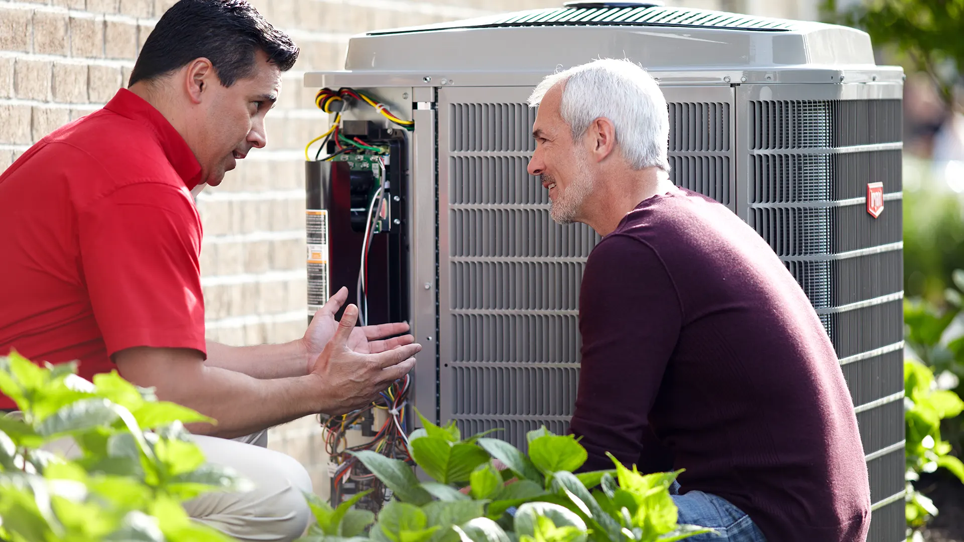HVAC Technician informing customer of equipment kneeling down beside unit | AC Repair | White Sands Cooling and Heating | whitesandsac.com
