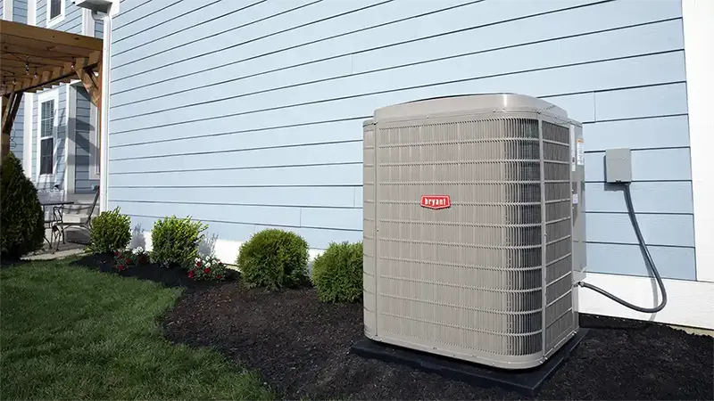 A Bryant Evolution Outdoor Unit installed beside a blue house | AC Install | White Sands Cooling and Heating | whitesandsac.com